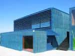Fachada principal de un moderno centro cultural con revestimiento azul