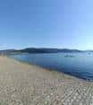 Vista de la zona costera del Parque da ETEA en Vigo con el mar y montañas al fondo.