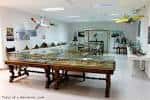 Sala de exposición interior con vitrinas y maquetas de aviación