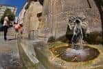 Primer plano de un chorro de agua termal con personas al fondo en As Burgas