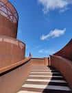 Escalera exterior de hormigón y acero corten que conduce a las estructuras del museo