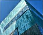 Vista angular de la fachada de cristal del MUNCYT bajo un cielo azul