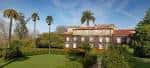 Vista panorámica del Pazo Quiñones de León y sus extensos jardines con palmeras