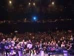 Vista de una gala benéfica con un gran público en un auditorio.