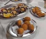 Platos de croquetas y zamburiñas en la mesa de un restaurante