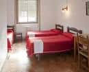 Habitación con tres camas individuales y mobiliario básico