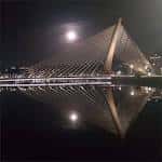 Puente de los Tirantes de noche con la luna llena reflejada en el agua