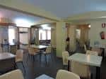 Sala interior con mesas y sillas, adecuada para reuniones o talleres
