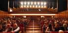 Interior del auditorio con butacas rojas y público asistiendo a un evento