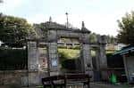 Entrada principal de piedra del Cementerio de Teis con su arco y detalles arquitectónicos