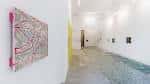 Interior de galería de arte con pasillo largo y obras expuestas