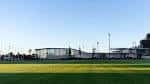 Vista exterior de los edificios y campos de la Ciudad Deportiva bajo un cielo despejado