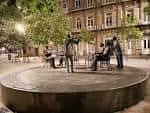 Esculturas del monumento 'La Tertulia' en la Praza de San Xosé durante la noche