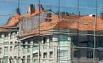 Reflejos de edificios históricos en la fachada acristalada de El Corte Inglés