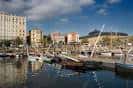 Vista diurna del puerto de Curuxeiras con múltiples embarcaciones y edificios costeros