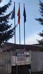 Entrada principal del CEIP Campolongo con tres banderas ondeando