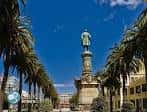 Estatua de Méndez Núñez rodeada de palmeras