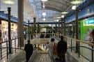 Zona de escaleras mecánicas en el interior del centro comercial con vistas a las tiendas