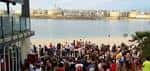 Multitud de personas en un evento al aire libre con la playa de fondo