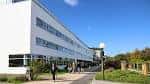 Edificio moderno del campus de la Universidade da Coruña con estudiantes