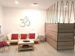 Área de recepción o sala de espera con sofá y el símbolo Om en la pared