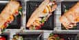 Variedad de bocadillos y sándwiches en platos negros