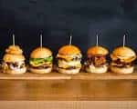 Variedad de cinco mini-hamburguesas gourmet alineadas
