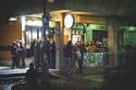 Vista exterior nocturna del Creedence Rock Bar con personas en la entrada