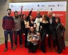 Grupo de profesionales posando en la alfombra roja de los Premios Paraugas, algunos con galardones