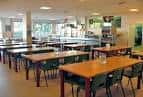 Interior del amplio comedor o cafetería con mesas dispuestas para servicio