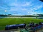Perspectiva del campo de juego y gradas del estadio bajo un cielo nublado