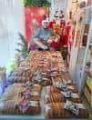 Interior de la panadería con un empleado detrás de una gran exposición de pan y productos horneados