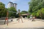Área de juegos infantiles con columpios y tobogán en el parque