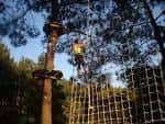Persona escalando una red de cuerdas en el parque multiaventura