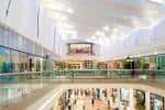 Perspectiva amplia del interior del centro comercial Los Prados, mostrando tres niveles