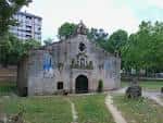 Vista frontal de la Capilla de Nuestra Señora de los Remedios con entorno verde