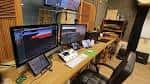 Estudio de producción o edición con múltiples monitores y equipo técnico