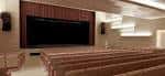 Interior del auditorio con butacas marrones y escenario vacío