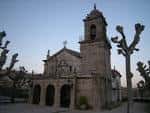 Iglesia de Santa Cristina de Lavadores al atardecer o en día nublado, con árboles desnudos
