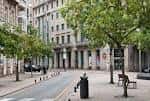 Calle arbolada adyacente a la Praza de San Xosé con arquitectura urbana
