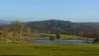 Vista panorámica del campo de golf con colinas y estanques