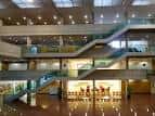 Amplio atrio interior de la Facultad de Derecho con escaleras y múltiples niveles