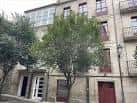 Fachada de edificio residencial con árboles en una calle de Ourense