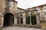 Arcada exterior de piedra que conecta diferentes secciones del edificio