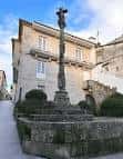 Cruceiro de la Praza das Cinco Rúas con edificios históricos al fondo