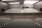 Interior del auditorio principal con asientos vacíos y escenario