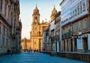 Calle adoquinada del casco histórico con la torre de una iglesia al fondo