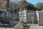 Sección de nichos y columbarios con cruz de piedra en el cementerio