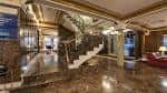 Gran vestíbulo del hotel con escalera de mármol y barandilla dorada