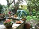 Detalle del jardín con escultura y plantas ornamentales